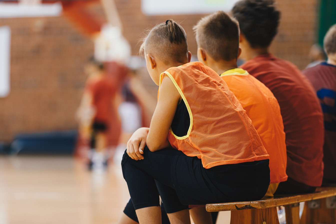 Youth Basketball Players Sitting on Substitutes' Bench and Watch